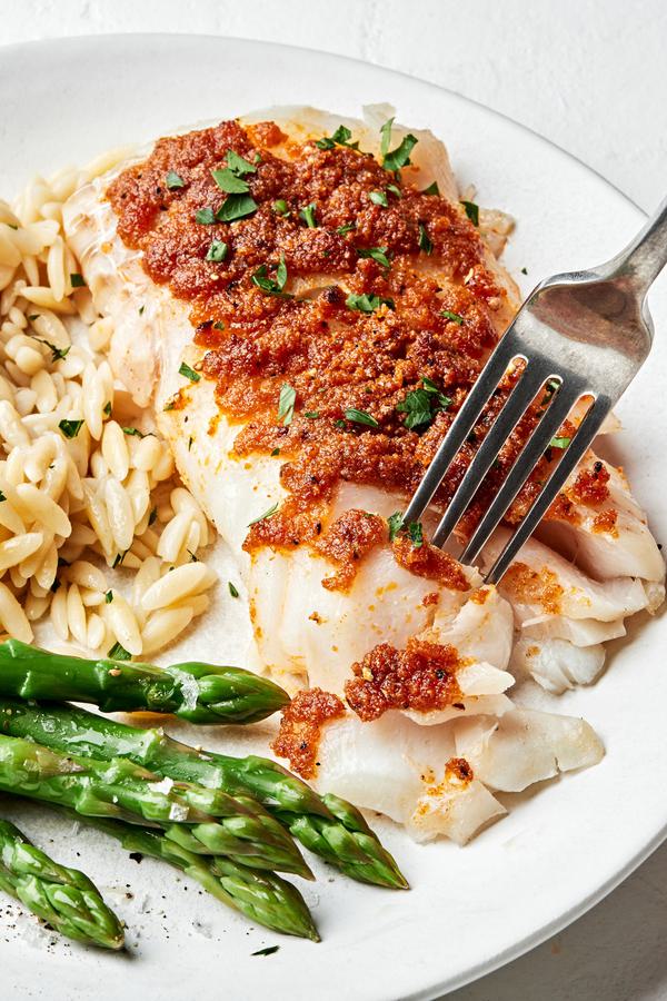 homemade baked cod seasoned with butter, garlic powder, onion powder, paprika, salt & pepper served with asparagus and rice