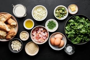 bacon, onion, garlic, swiss chard, olives, eggs, cream, butter, panko, feta, chives and bread in prep bowls