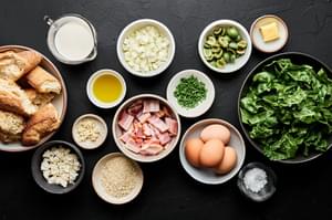 bacon, onion, garlic, swiss chard, olives, eggs, cream, butter, panko, feta, chives and bread in prep bowls