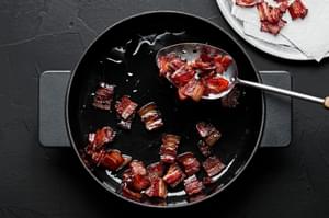 bacon being cooked in a skillet