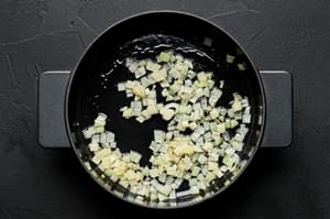 chopped onions being cooke din olive oil in a skillet