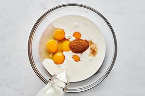 eggs, milk, cream, vanilla and cinnamon being added to a glass bowl
