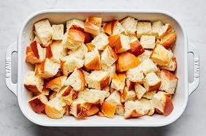 challah bread torn into 1 inch pieces in a buttered casserole dish