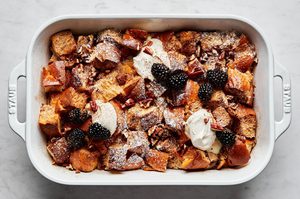 baked french toast in a baking dish topped with whipped cream and blackberries, perfect for holidays and weekend brunch