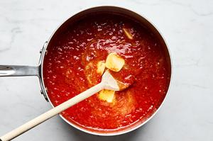 jarred marinara sauce and butter being stirred together in a pot