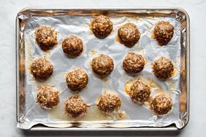 baked italian meatballs on a foil lined baking sheet made with ground beef, Italian sausage, Parmesan, breadcrumbs and spices