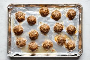 baked italian meatballs on a foil lined baking sheet made with ground beef, Italian sausage, Parmesan, breadcrumbs and spices