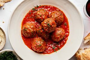 a bowl of Italian meatballs in marinara sauce made with ground beef and Italian sausage topped with parsley