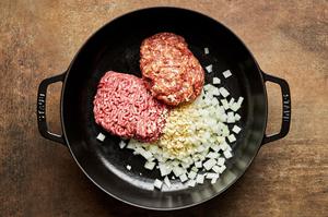 ground mild Italian sausage, ground beef, onion, and garlic being cooked in a pot
