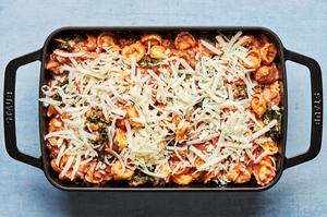 tortellini and homemade pasta sauce mixed together in a baking dish topped with mozzarella cheese