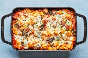baked tortellini in a baking dish fresh out of the oven made with italian sausage, kale and mozzarella