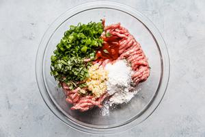 ground pork, corn starch, garlic green onions and cilantro in a bowl for banh mi burgers