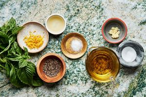 garlic, lemon zest, lemon juice, basil, olive oil, sugar, salt and pepper in bowls to make homemade basil vinaigrette