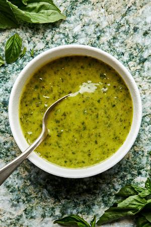 homemade basil vinaigrette in a small bowl made with garlic, lemon zest & Juice, basil, olive oil, sugar, salt and pepper