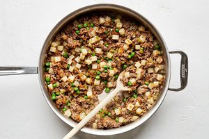 savory ground beef empanada filling in a skillet made with potatoes, onions, carrots and peas