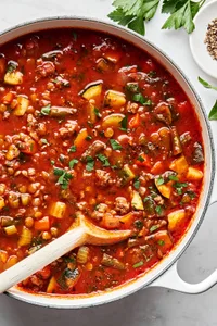 a pot of beef and lentil soup made with ground beef, zucchini, green beans, carrots, onion, celery and lentils