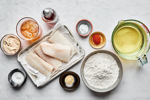raw cod, flour, beer, spices, baking powder and canola oil in prep bowls to make beer battered fish