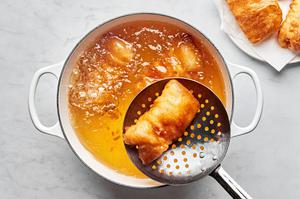 beer battered fish being fried in a pot of vegetable oil