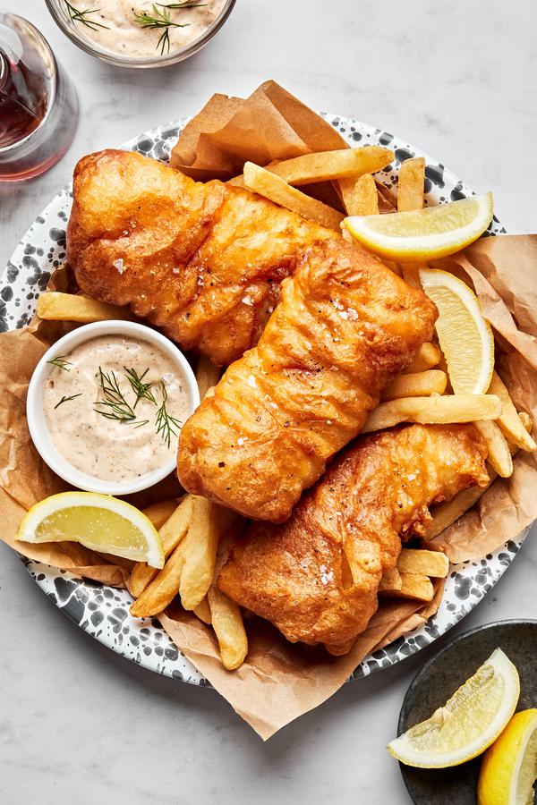 homemade beer battered fish served with french fries, lemon wedges and tartar sauce