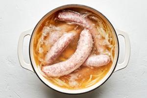 beer, onion, onion powder, garlic powder, pepper, salt and bratwurst cooking in a large pot