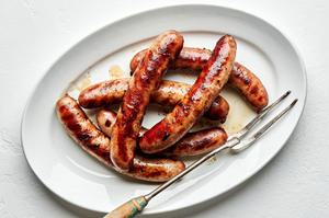 grilled beer brats on a serving platter first boiled in beer, onion, onion powder, garlic powder, pepper, and salt