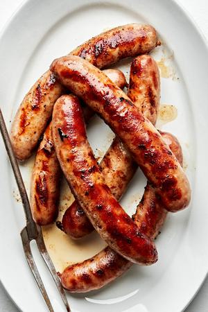 grilled beer brats on a serving platter first boiled in beer, onion, onion powder, garlic powder, pepper, and salt