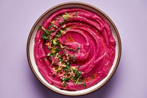 beet hummus in a bowl made with chickpeas, beets, tahini, olive oil, lemon zest & juice, red wine vinegar & spices