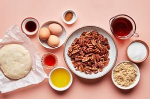 pie crust, pecans, eggs, brown sugar, sugar, vanilla, butter, bourbon, corn syrup and cinnamon in prep bowls