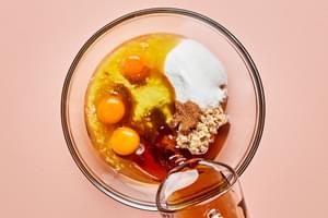 eggs, corn syrup, sugar, brown sugar, vanilla, butter, cinnamon, and bourbon  in a glass bowl