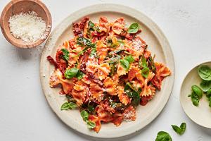 bow tie pasta made with tomatoes, basil, cream, spinach, sun dried tomatoes and topped with parmesan