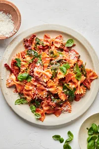 bow tie pasta made with tomatoes, basil, cream, spinach, sun dried tomatoes and topped with parmesan
