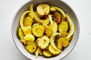 homemade bread and butter pickles and slices of sweet onions in a bowl