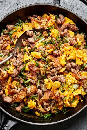 breakfast burrito filling in a skillet (potatoes, eggs, sausage and green onions)