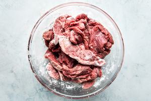thin strips of beef with cornstarch in a bowl