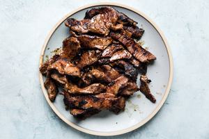 thin slices of marinated cooked beef on a plate.
