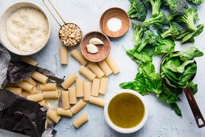 Ingredients for broccoli pesto pasta, rigatoni, garlic parmesan, olive oil, pine nuts, salt, basil