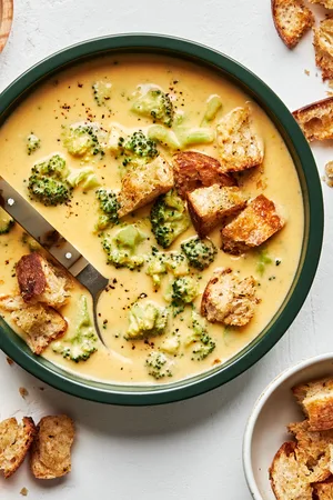 Creamy broccoli cheddar soup in a bowl, topped with crunchy golden croutons, perfect for a cozy lunch or dinner