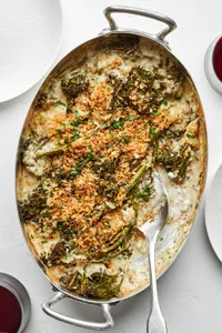 homemade broccolini au gratin being scooped out of a baking dish