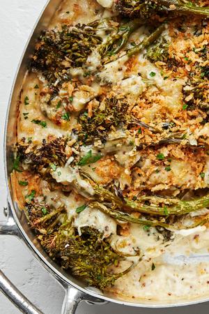 homemade broccolini au gratin being scooped out of a baking dish