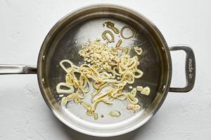 minced shallot being cooked in olive oil in a skillet