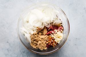 thinly sliced steak, thinly sliced onions, minced garlic and brown sugar in a bowl