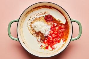garlic, chicken stock, sugar, tomatoes, tomato paste, cream, parmesan, spices and lemon juice cooking in a pot