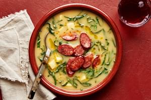 a bowl of homemade caldo verde soup with smoked sausage, onion, potatoes, spices and collard greens