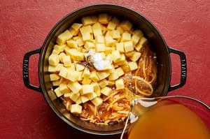potatoes, onion, spices and chicken stock cooking in a large soup pot