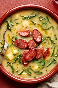 a bowl of homemade caldo verde soup with smoked sausage, onion, potatoes, spices and collard greens