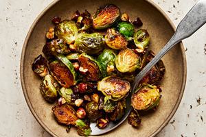 candied brussels sprouts with hazelnuts in a serving bowl with a spoon