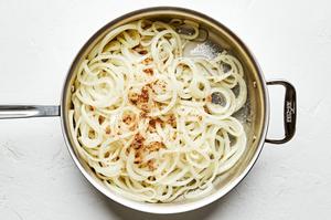 onions being caramelized in a skillet with olive oil, butter and brown sugar
