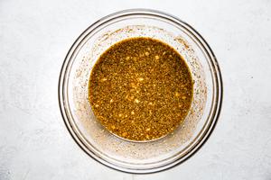 orange juice, lime juice, olive oil, garlic, oregano, chili powder, salt, cumin, pepper, and cayenne mixed in a bowl