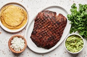 warmed corn tortillas, diced onion, carne asada, cilantro and guacamole in prep bowls