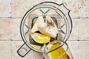pear, olive oil, vinegar, honey, salt, pepper, and lemon juice being added to a blender